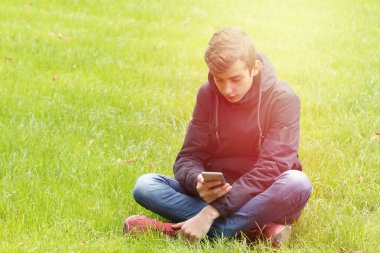 Genç parkta bir telefon ile