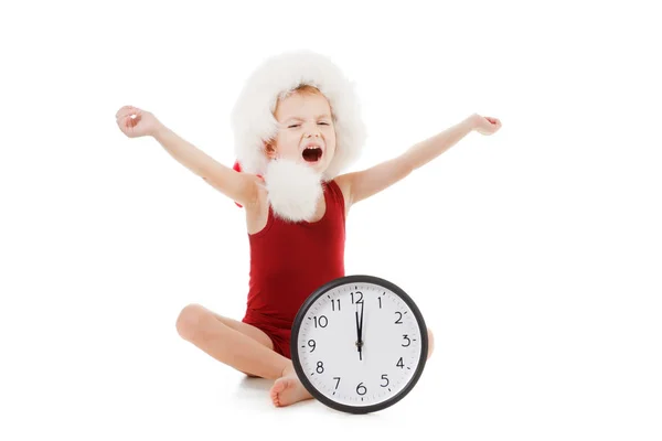 Little boy wearing Santa Claus red hat with clock isolated on white. Christmas concept. — Stock Photo, Image