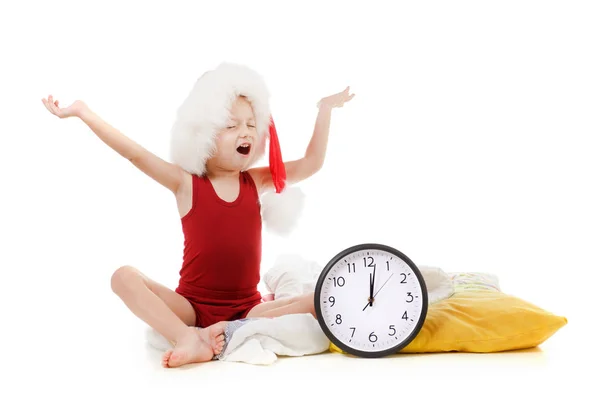 Little boy wearing Santa Claus red hat with clock isolated on white. Christmas concept. — Stock Photo, Image