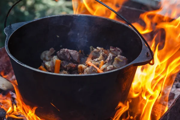 Bowler turístico con comida en hoguera, cocina en la caminata, actividades al aire libre. Preparación de pilaf. — Foto de Stock