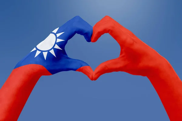 Handen vlag van Taiwan, de vorm van een hart. Concept van land symbool, op blauwe hemel. — Stockfoto