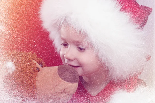 Feliz Natal pequena criança sonhando e urso na janela olhando para o inverno . — Fotografia de Stock