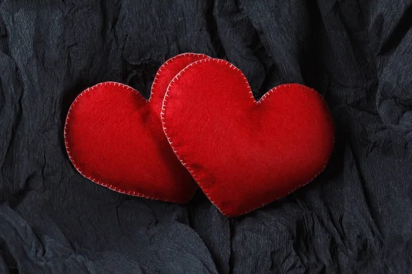 Siyah kağıt arka plan üzerinde kırmızı Kalpler