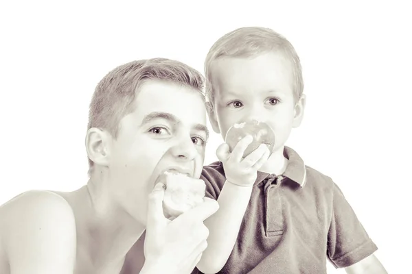 Hermanos jugando y comiendo manzanas . — Foto de Stock