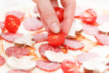 Domates üzerinde ham pizza mozzarella ve salam koyarak Cook