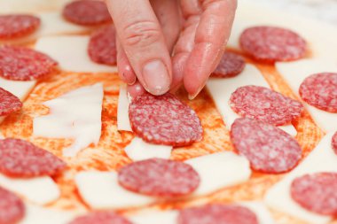 Ham bir pizza Mozzarella peyniri üzerine koyarak salam yemek