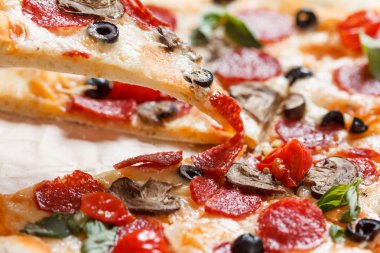 Eritilmiş peynir damlama ile sıcak pizza dilimi. Beyaz izole.