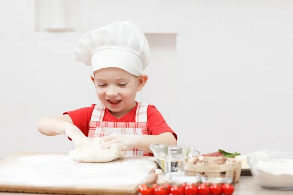 Criança pequena fazendo pizza ou massa de massa — Fotografia de Stock