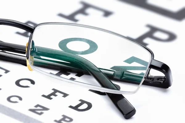 Läsglasögon med öga diagram på vitt öga — Stockfoto
