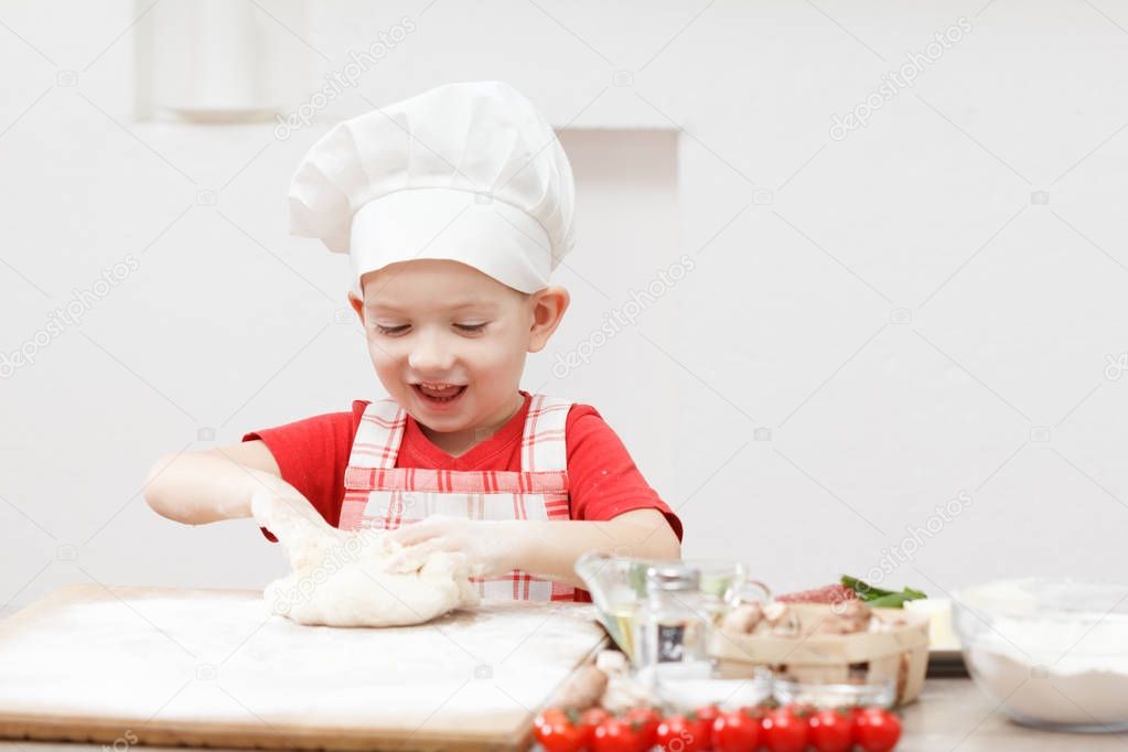 Little child making pizza or pasta dough
