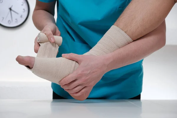 Närbild av manliga läkare bandage foten av kvinnlig patient — Stockfoto