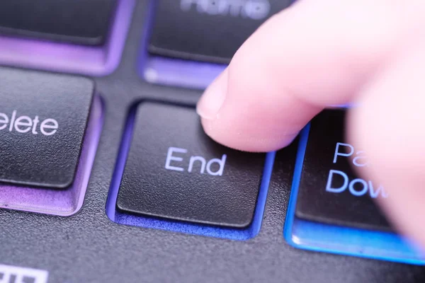 Finger presses End key on keyboard