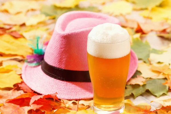 Cerveza vaso pinta octoberfest picnic sobre fondo natural con sombrero y hojas de otoño —  Fotos de Stock