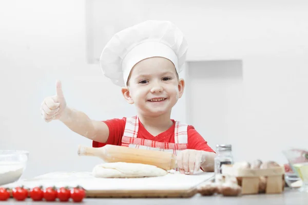 Menino com chapéu de chef preparando a massa de pizza — Fotografia de Stock