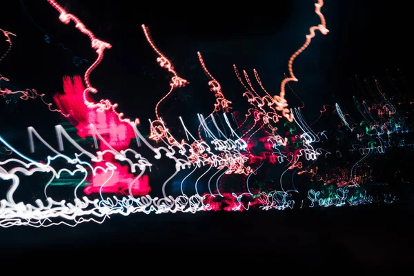 Abstrakter Hintergrund verschwommene farbige Markierungen von schnell fahrenden Autos in der Nacht — Stockfoto