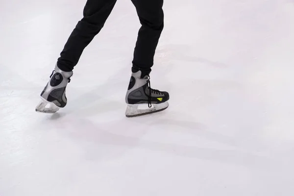 Pés masculinos rolando em patins na pista de gelo — Fotografia de Stock