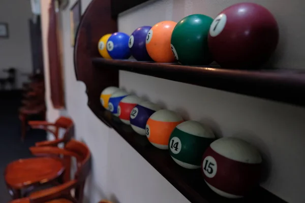 Balls for pool billiards on the shelf colored or white balls for billiards on a wooden background.