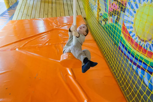 Boy swinging on a rope at a playground — Stock Photo, Image