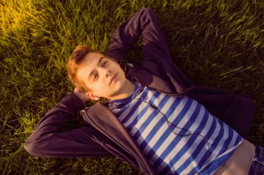 genç çocuk telefon ile çim üzerinde yalan