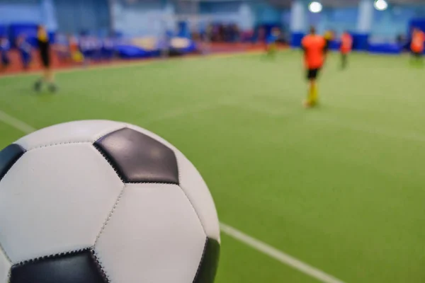 Bola de futebol no estádio e jogadores de futebol desfocados em campo — Fotografia de Stock