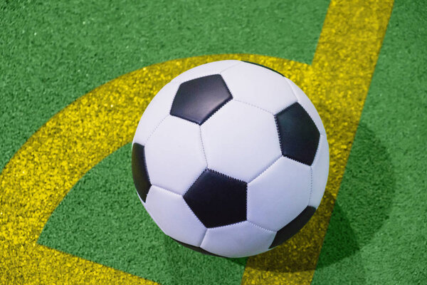 Футбольный мяч на угловой линии на искусственной зеленой траве вид сверху
