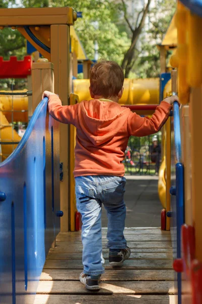 Niño jugando en el patio de juegos de color —  Fotos de Stock