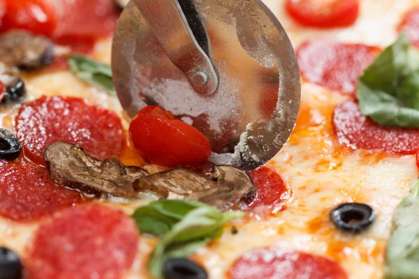 Özel bıçakla dilimlenmiş pepperonili pizza..