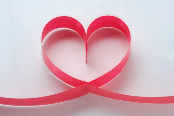 Herz aus rotem Band auf weißem Hintergrund. romantische Liebe Konzept. Valentinstag zum Geburtstag, Feiertag — Stockfoto