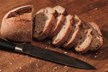 Bütün güzel kokulu ekmek masanın üzerinde. Gıda bıçak ile kesme tahtası üzerinde