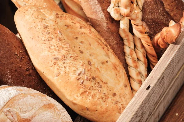 テーブルの上の香ばしいパン。木製の箱に食品のコンセプト — ストック写真