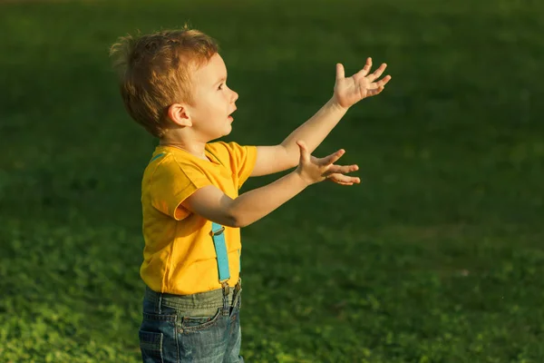 Schattige roodharige jongen reikt tot de zonsondergang. — Stockfoto