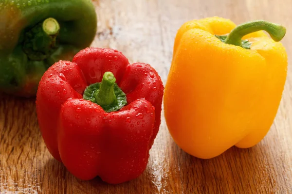 Green , yellow and red bell pepper with water drops closeup