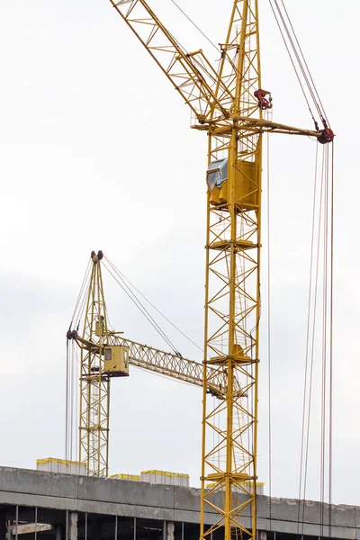 Guindaste de construção em construção contra o céu azul — Fotografia de Stock