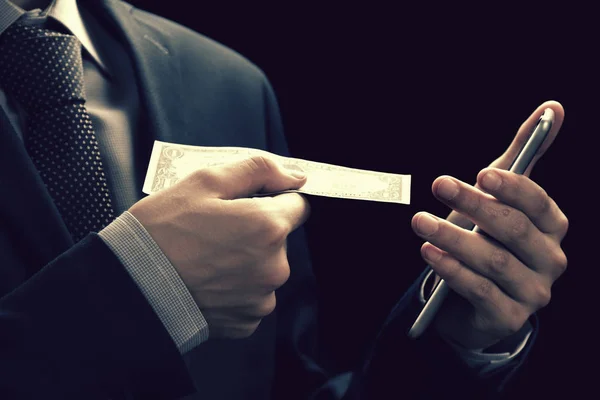 Transferencia de dinero de banca en línea de tecnología, concepto de comercio electrónico. Hombre usando teléfono inteligente con billetes de dólar de la pantalla —  Fotos de Stock