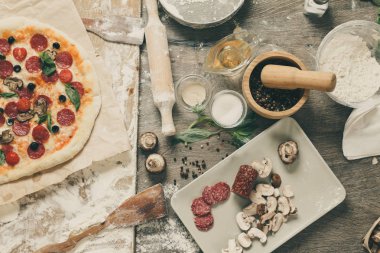 Üstten Görünüm malzemeler, domates, salam ve ahşap masa üzerinde mantar pizza pişirme