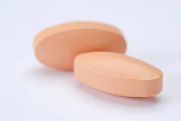 Roze pillen en tabletten geïsoleerd op witte achtergrond — Stockfoto