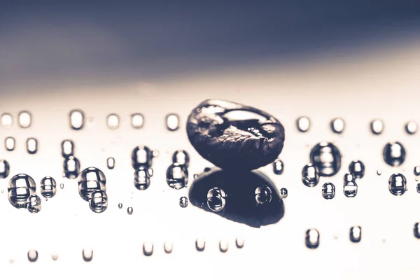 闪亮的新鲜烘焙咖啡宏豆的玻璃背景与水滴 — 图库照片