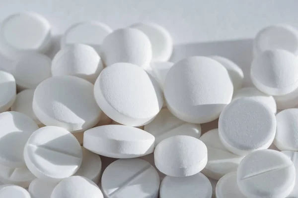 Montón de muchas píldoras de drogas blancas que yacen en una pila — Foto de Stock