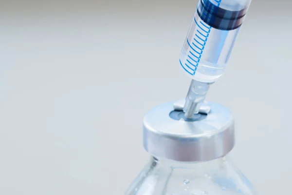 Geneeskunde in flesjes en spuiten, klaar voor de vaccin injectie, behandeling van kanker, pijnbehandeling op blauw — Stockfoto