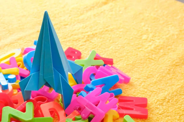 Letras coloridas del alfabeto con cohete de origami de juguete azul. Concepto educativo —  Fotos de Stock
