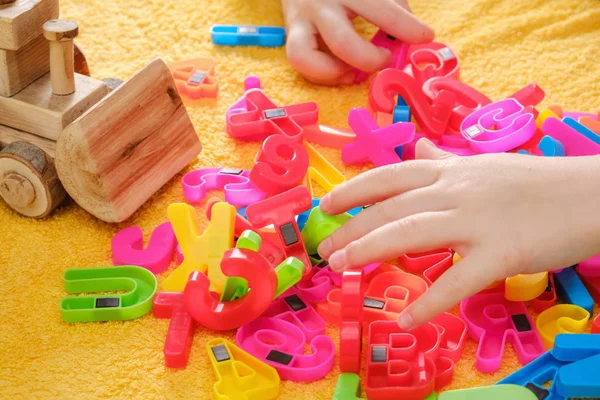 カラフルな文字と遊ぶ赤ちゃんの小さな手 — ストック写真