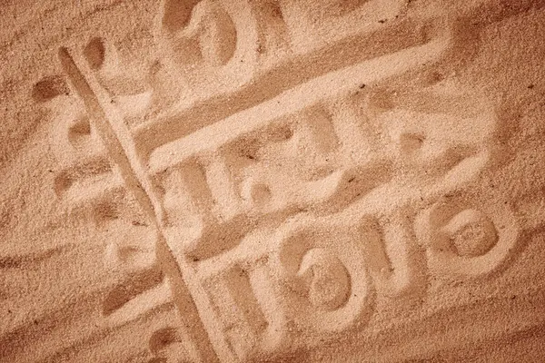 Рисунок на песочном фоне — стоковое фото