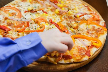 Ahşap bir arka plan üzerinde pizza yemek çocuk kesilmiş parça pizza