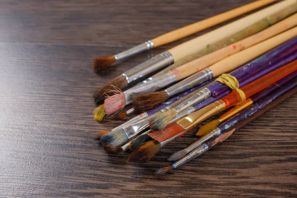 Artist paint brushes on wooden background close-up — Stock Photo, Image