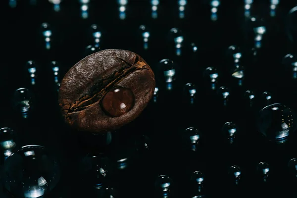 Café frais torréfié macro grains sur fond de verre avec gouttes d'eau vue du dessus — Photo