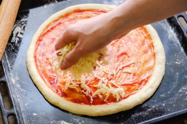 Taze İtalyan çiğ pizzası, geleneksel usulde fırında pişirme tepsisi üzerinde hazırlanma.