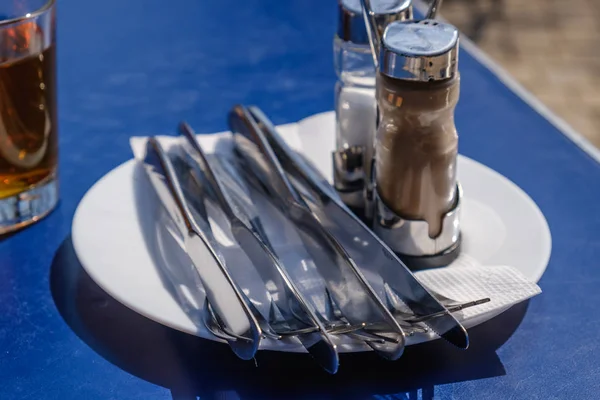 Tenedor y cuchillo en un plato. Ajuste de la mesa en un café — Foto de Stock