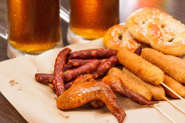 Alman Milli yemekleri tuzlu kraker mısırlı sosis füme kanatları ve bira oktoberfest ahşap masaya yokmu.