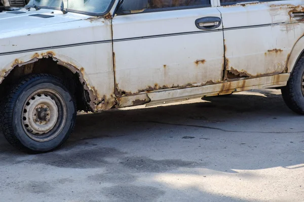 Old rotten rusty car is abandoned on the road — Stock Photo, Image