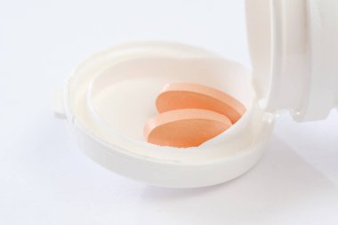 Tablet ilaç yanında plastik şişe yalan yığını. Hapları ve şişe beyazdır. Beyaz izole